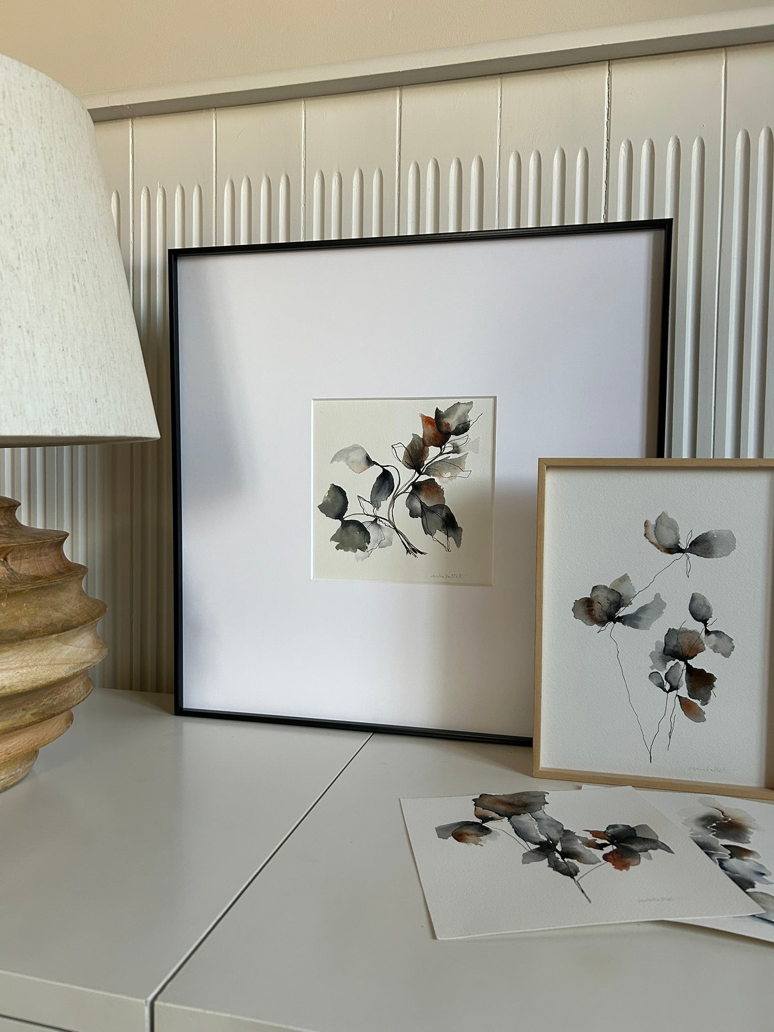 Cuadro en ambiente apoyado en una pared encima de un mueble de una habitación