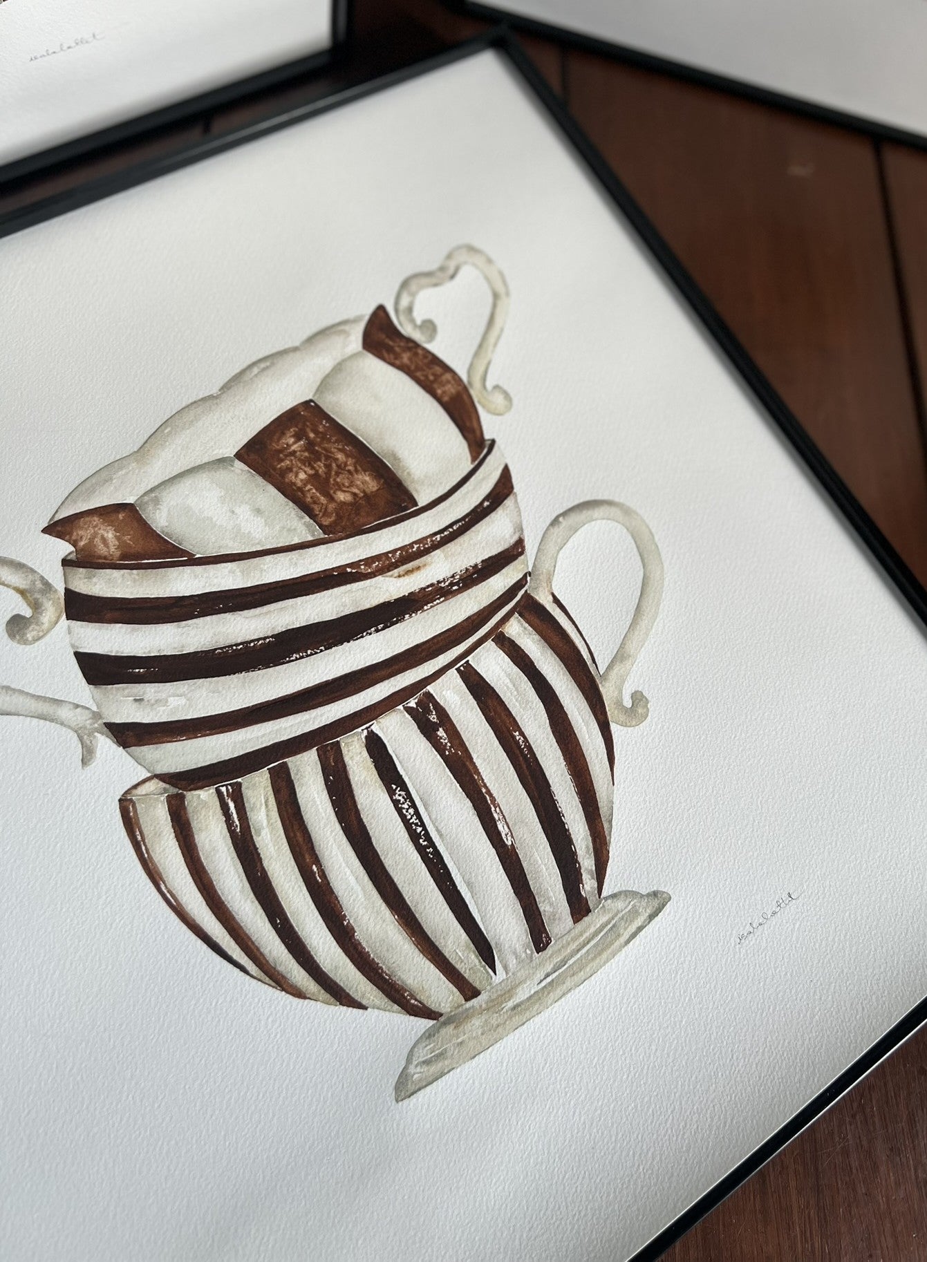 Detalle cuadro en acuarela con tazas en tonos tierra, con rayas, enmarcado, ideal para cocina