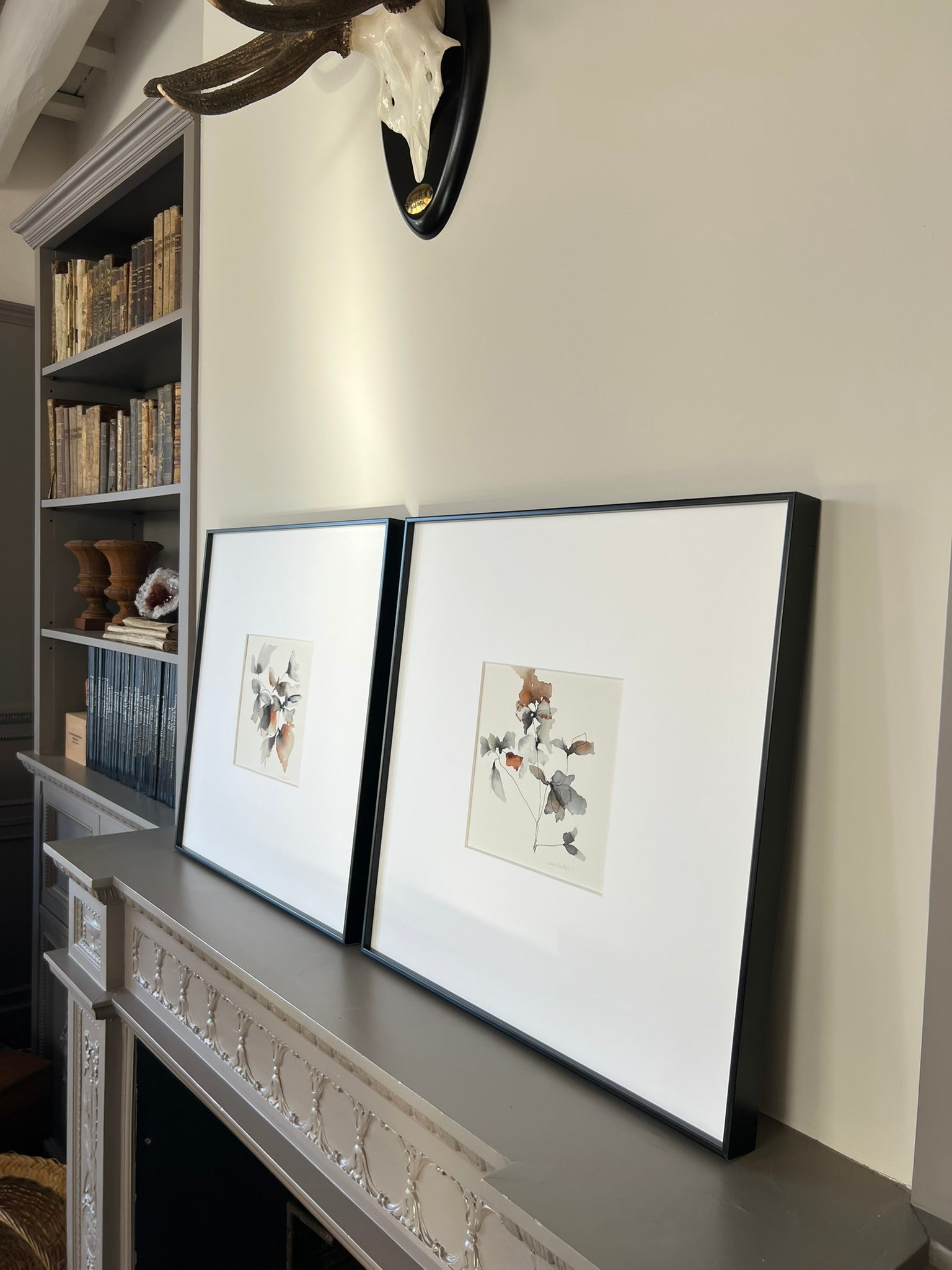 Cuadros decorativos apoyados en una pared de salón fotografiado en revista El Mueble