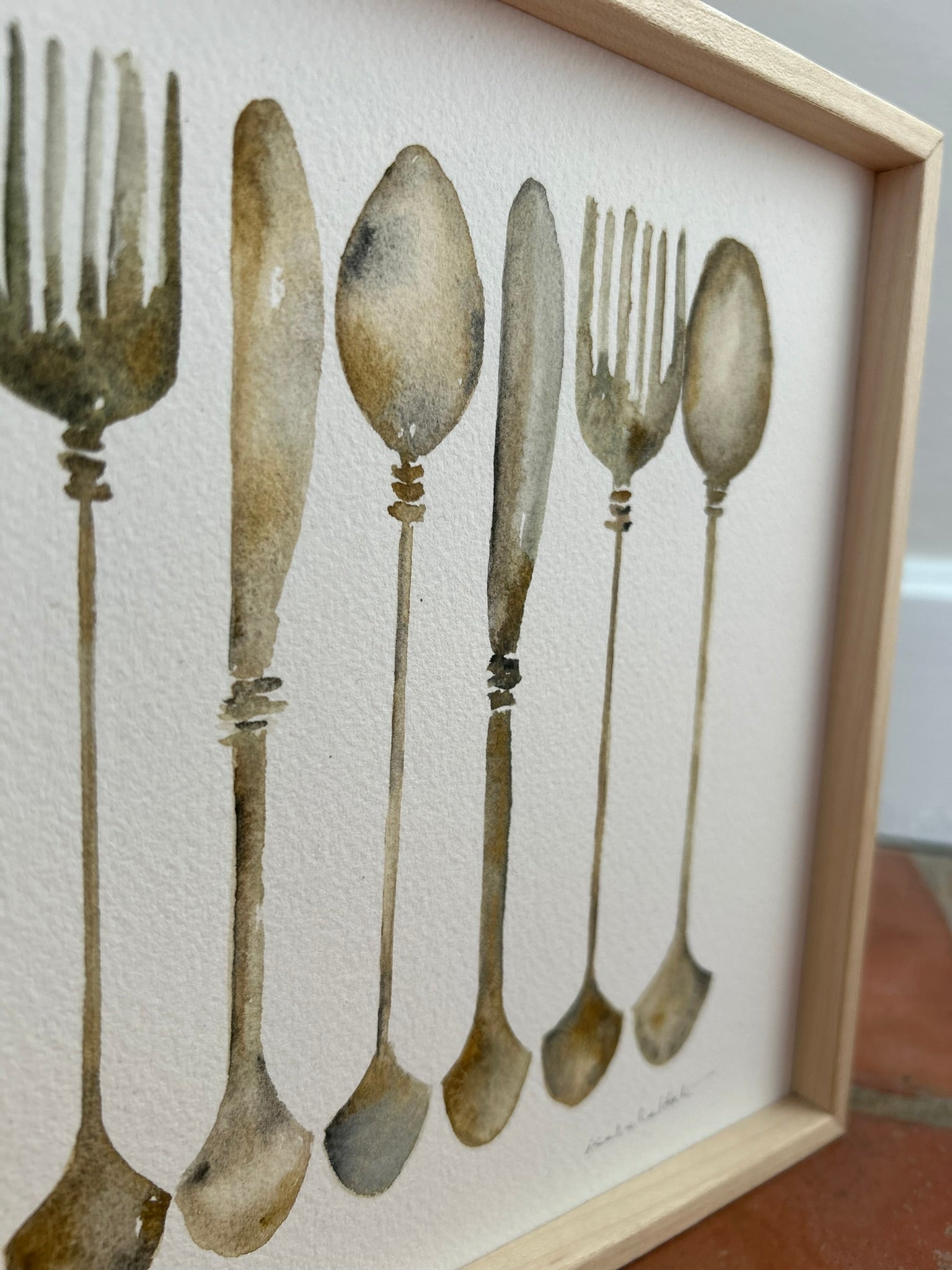 Detalle cuadro decorativo para cocina, son unos cubiertos, cuchara, tenedor y cuchillo, en tonos plata y óxido, que recuerdan a la cubertería antigua. Pintados a mano por Isabel Altet
