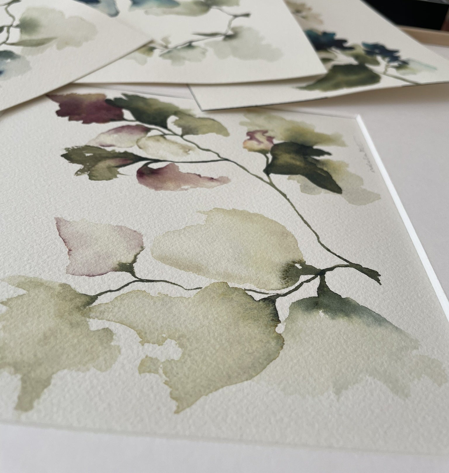 Detalle dibujo floral pintado a mano en acuarela con tonos verdes y malva