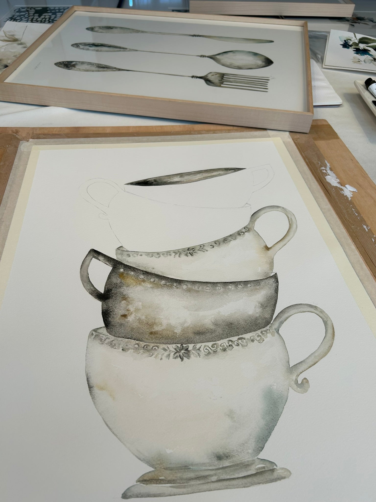Dibujo en progreso de unas tazas amontonadas para decorar un cuadro para la cocina de manera original