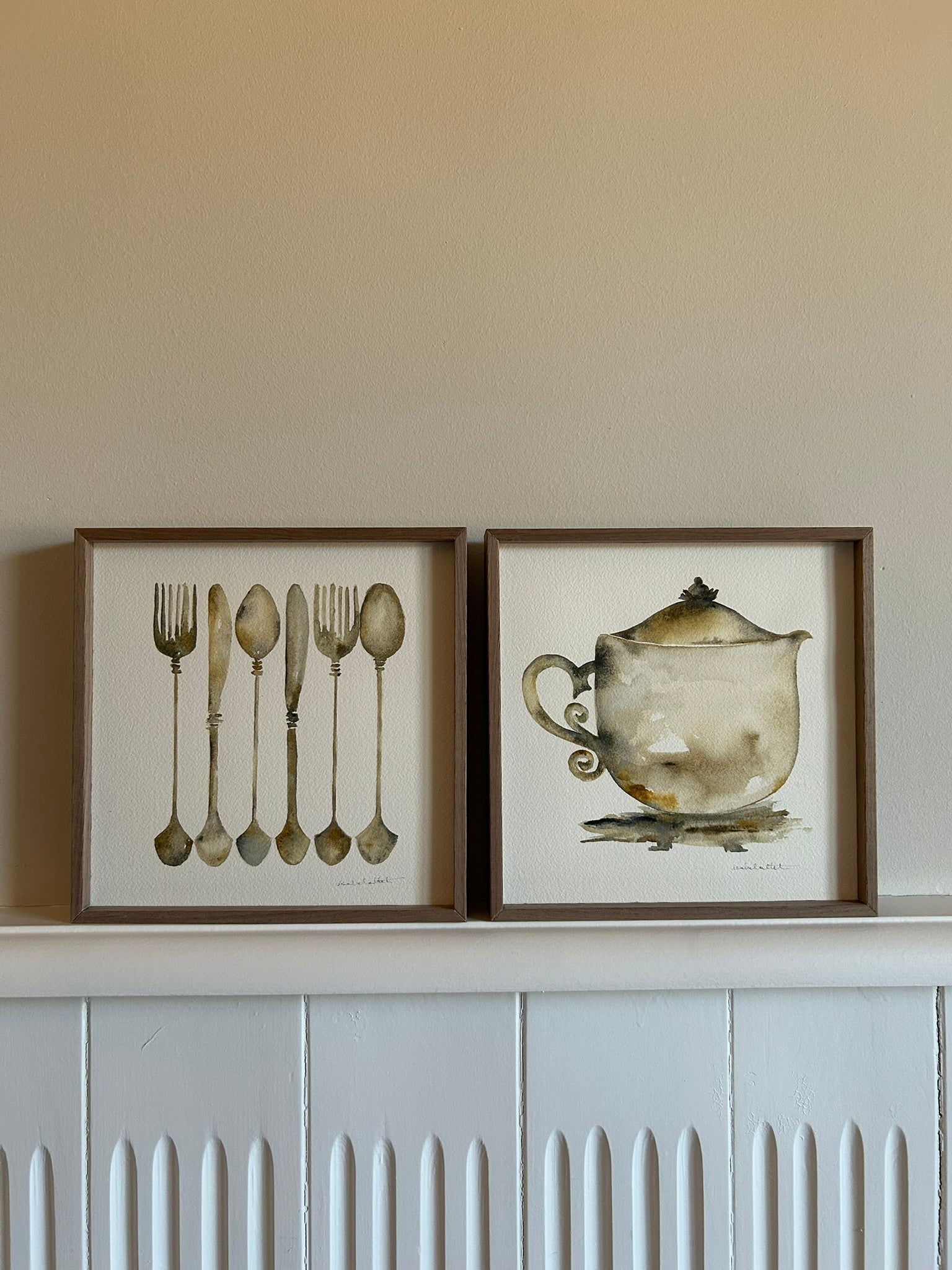 Pareja de cuadros, una tetera, unos cubiertos, para decorar la encimera, una estantería o un rincón con encanto de la cocina o el comedor. Son cuadros elegantes y en tonos neutros para que no cansen